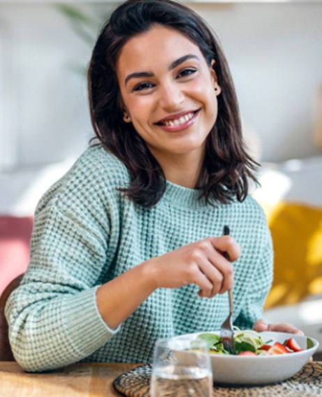 a smiling woman eating lunch