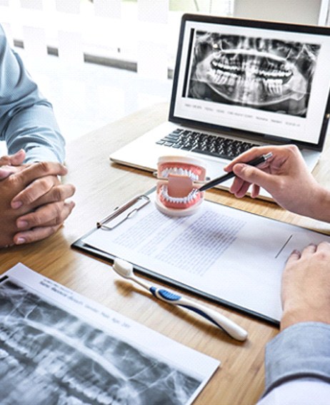 an implant dentist in Dallas consulting with a patient about treatment