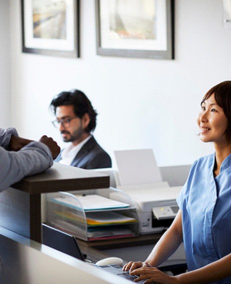 patient speaking with the front desk staff at a dental office