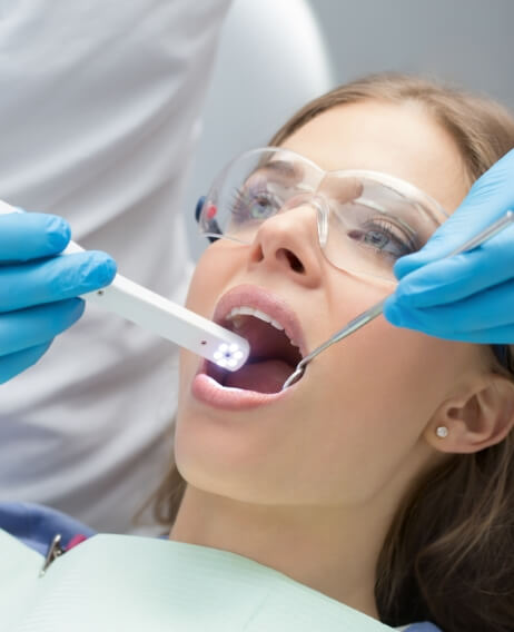 Dental patient having her teeth scanned by her dentist