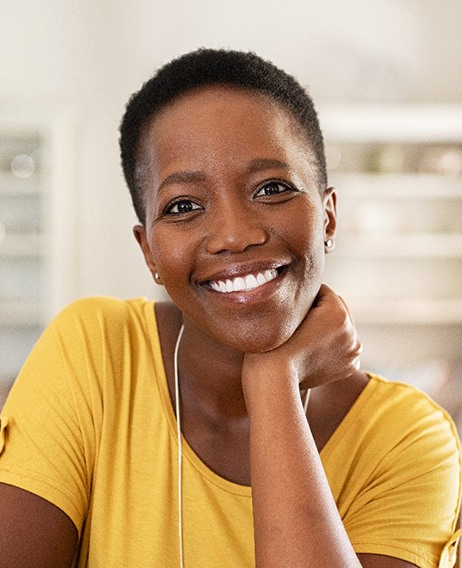 Woman in yellow shirt smiling at home