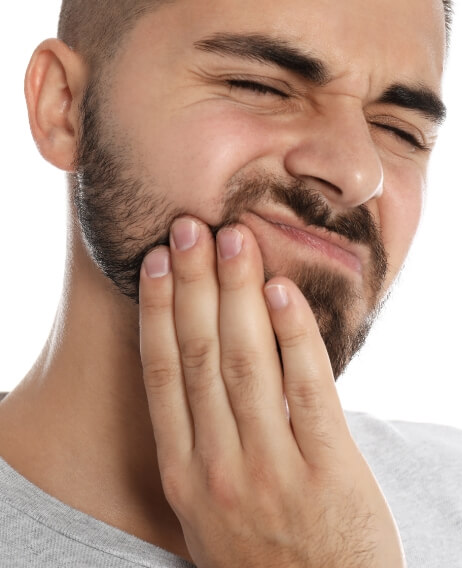 Man wincing and holding his cheek in pain