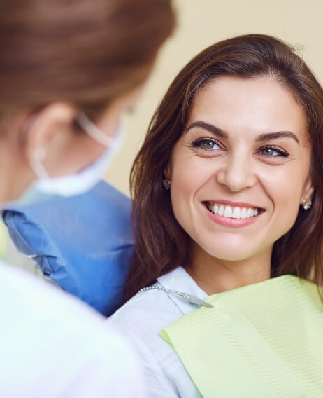 Woman in dental chair smiling at her dentist