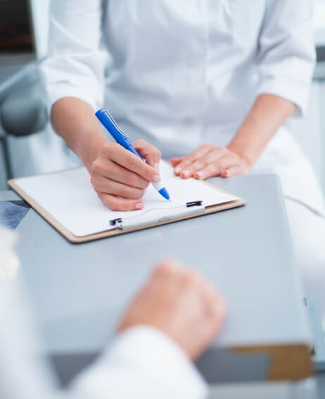 Dental patient filling out paperwork on a clipboard