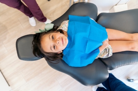 Young girl in dental chair looking up toward the camera