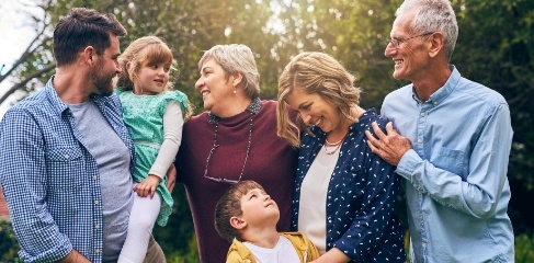 Three generations of a family smiling together outdoors