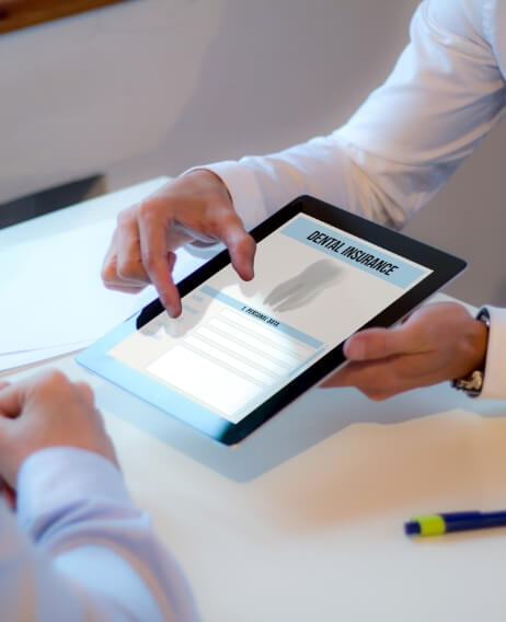 Two people looking at dental insurance form on tablet