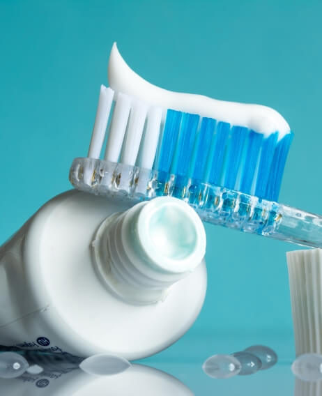 Tube of toothpaste next to a toothbrush