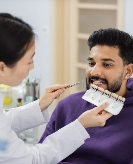 Dentist using a shade guide on a patient