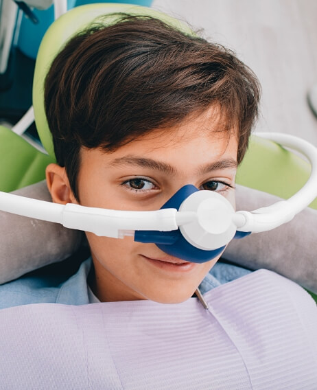 Young boy in dental chair wearing nitrous oxide mask