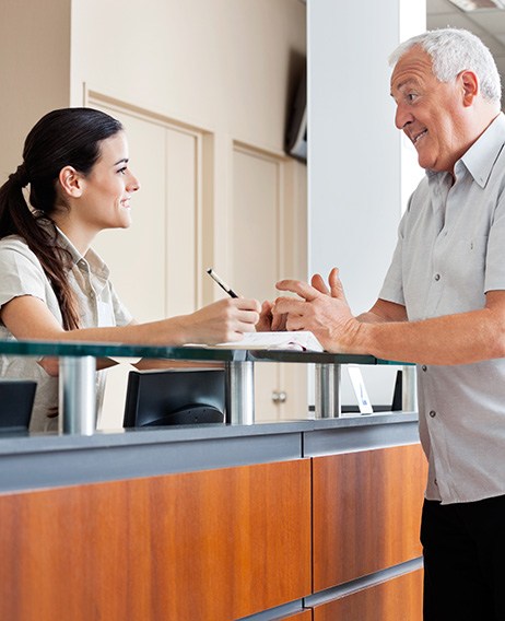 a dental patient speaking with a front desk worker